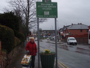 Resident Margaret Endsor with one of the locally crafted planters welcoming visitors to the village.